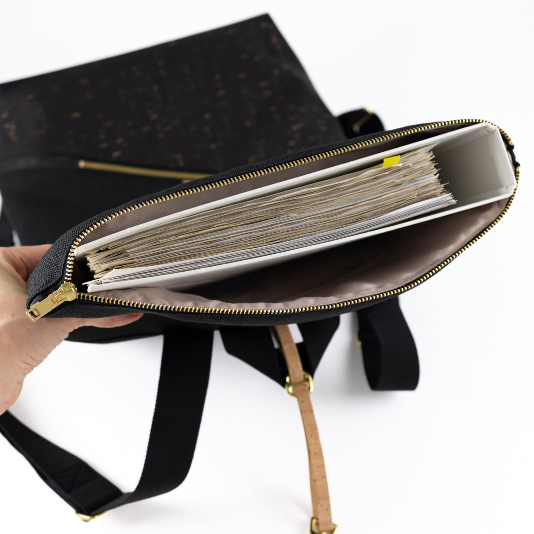 NOAS Rolltop Rucksack Everyday Size M – schmaler Büro Ordner wird in das geräumige Hauptfach gesteckt