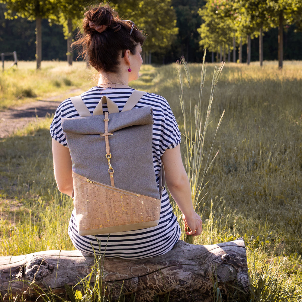 Tragebild: Rucksack auf dem Rücken im Sommer auf einem Baumstamm in der Natur