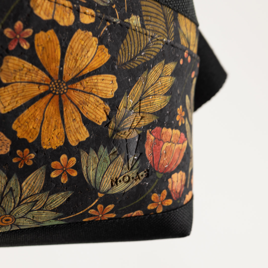 Nahaufnahme des floralen Kork Flower Musters – gelbe, rote, türkise Blüten auf schwarzem Hintergrund mit grünen Blättern.