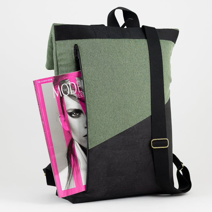 Rückansicht des Rolltop Rucksacks mit Zeitschrift, die aus dem Laptopfach gezogen wird.