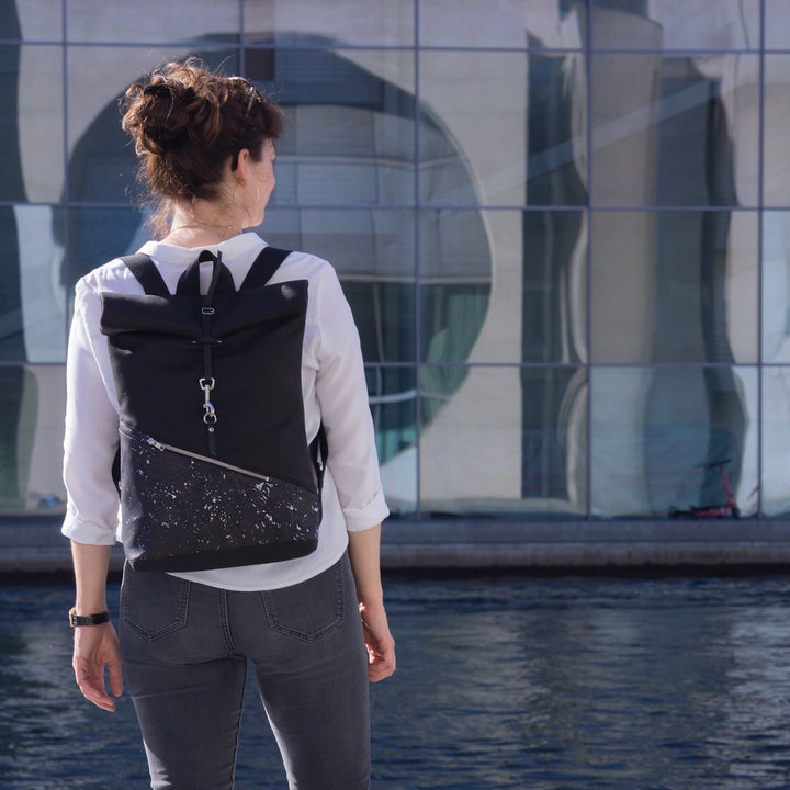 Kleiner veganer Rolltop Rucksack von NOAS Berlin – getragen im urbanen Regierungsviertel Berlin Mitte, stilvolles All-Black-Design für modernen Lifestyle.